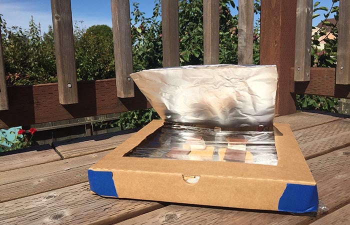 Solar oven smores cooking on a deck